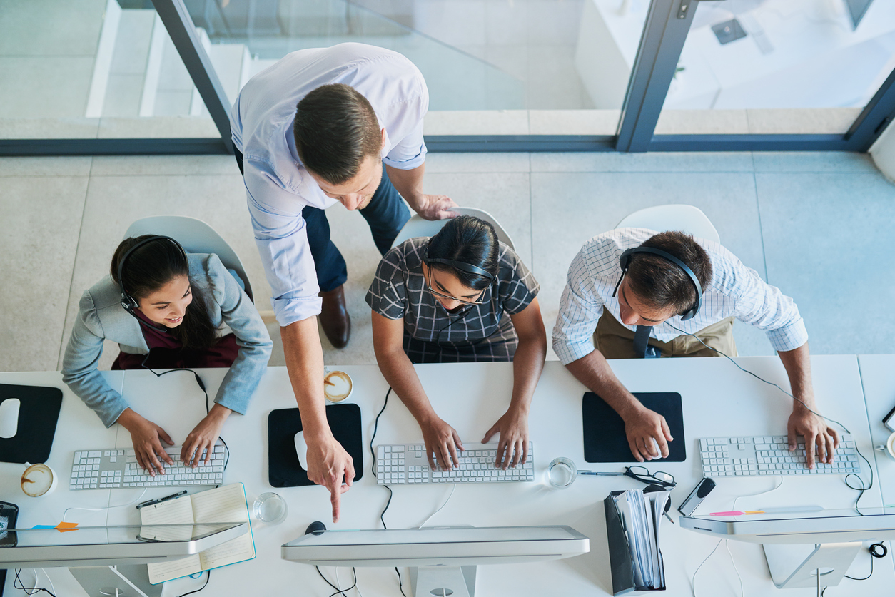 High angle shot of a man assisting his colleagues in a call center