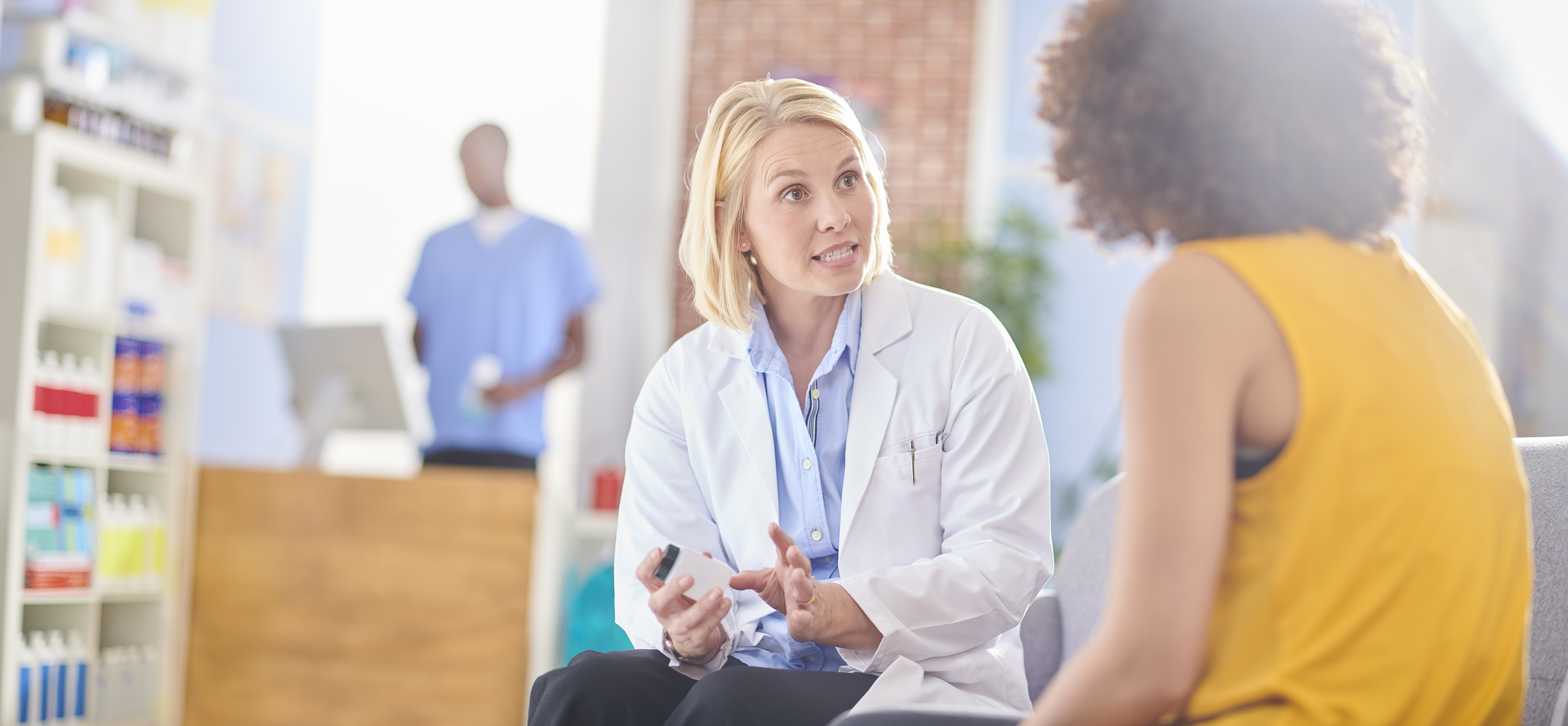 pharmacist discussing medication with senior customer with checkout counter in the background